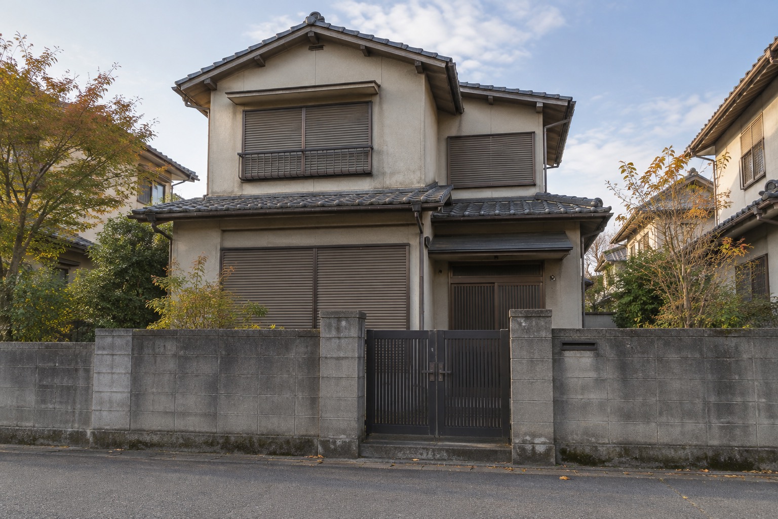 道路側から見た、門と雨戸を閉じた日本の戸建て住宅。空き家の維持管理を表す編集部イメージ。
